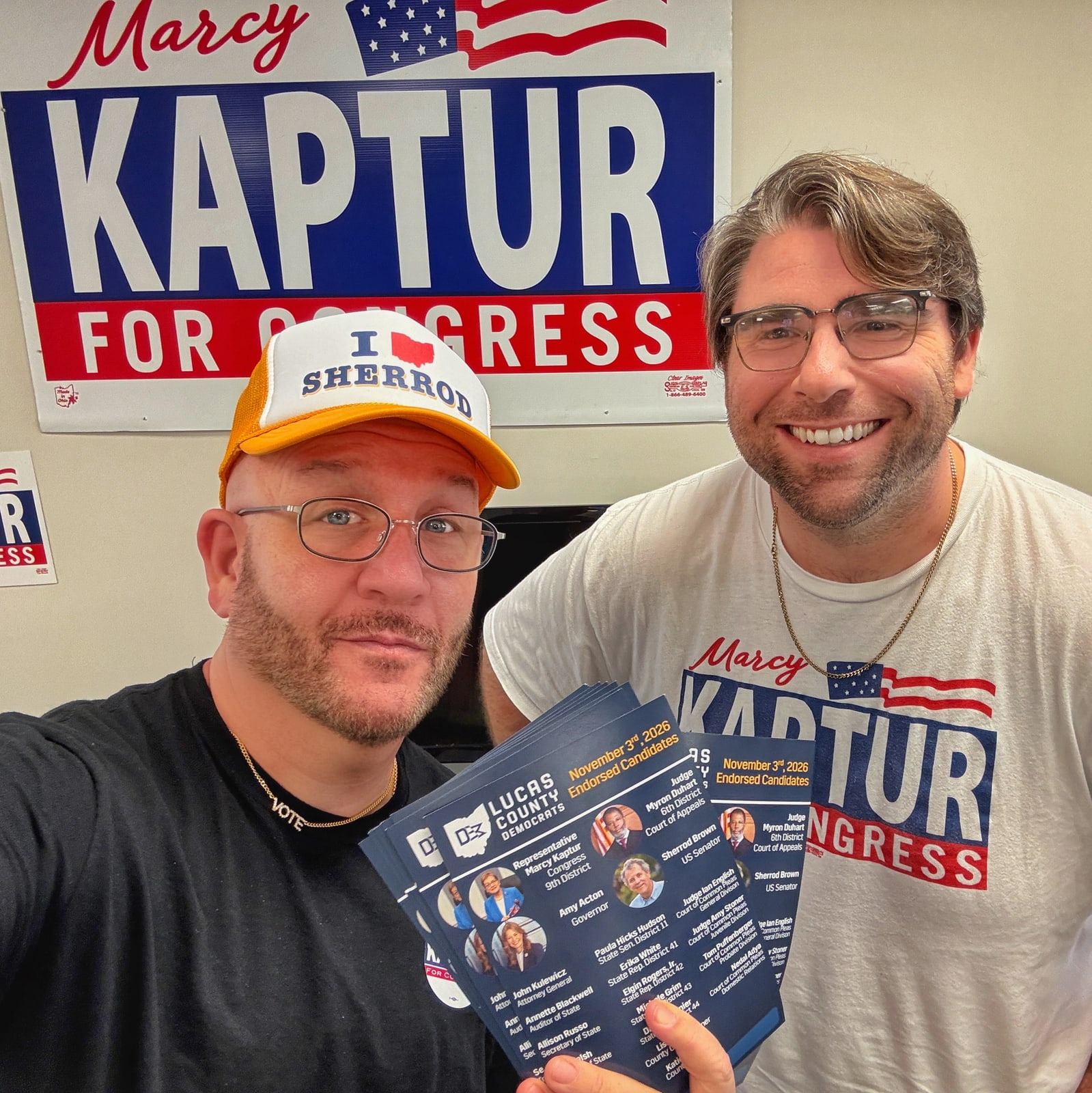 Blue Moreno holding campaign literature beside a man in a Marcy Kaptur shirt in Toledo