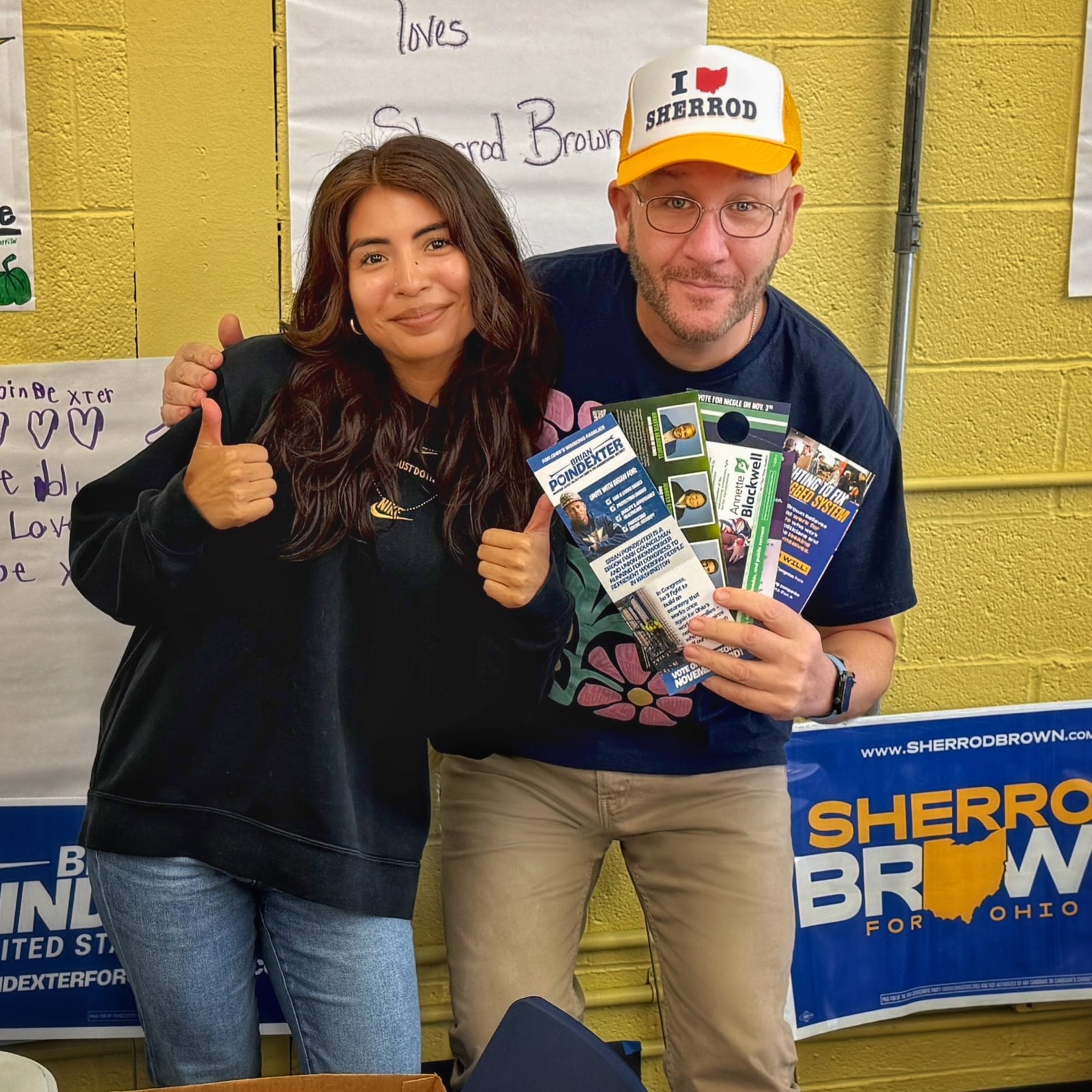 Blue Moreno holding campaign literature beside a woman giving two thumbs up in Parma